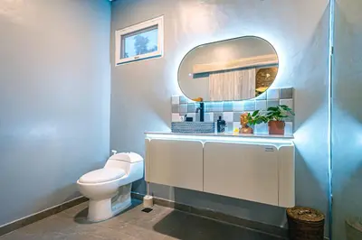 a bathroom with a white toilet and a mirror at Amshiga 1 in Jimbaran