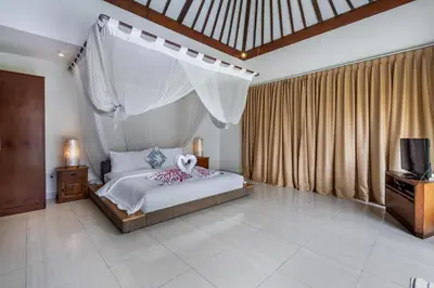 a bedroom with a bed and a tv in it at Balima Villa in Seminyak