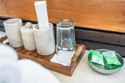 a wooden tray with a glass vase and three candles at Balima Villa in Seminyak