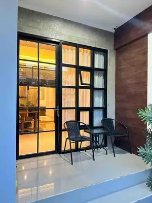 a patio with two chairs and a table and windows at Odua Mezzanine - Bromo in Denpasar