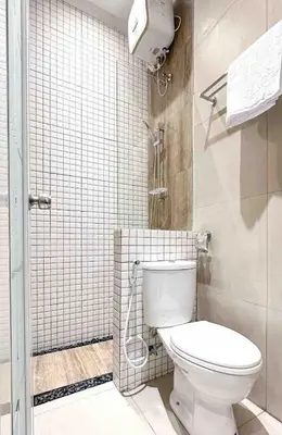 a small bathroom with a toilet and a shower at Odua Mezzanine - Bromo in Denpasar