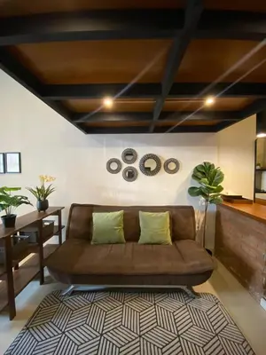 a living room with a brown couch and a table at Odua Mezzanine - Bromo in Denpasar