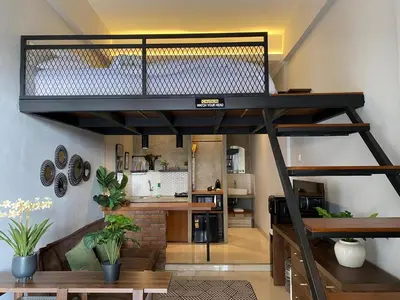 a loft bed in a room with a kitchen at Odua Mezzanine - Bromo in Denpasar