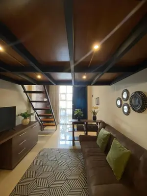 a living room with a brown couch and a table at Odua Mezzanine - Bromo in Denpasar