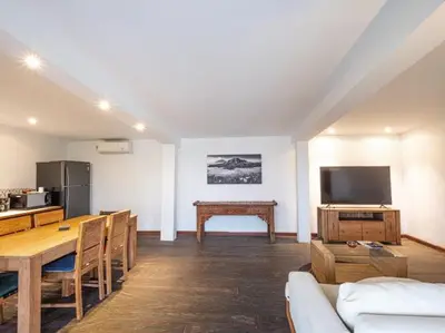 a large living room with a table and a kitchen at Villa Melissa in Kerobokan
