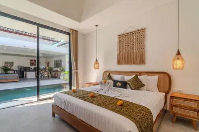 a bedroom with a large bed and a swimming pool at Villa Vela 1 - Brand new 3 bedroom villa in Seminyak