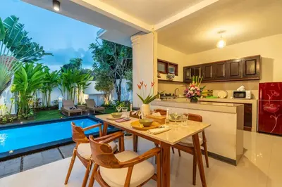 a kitchen and living room with a table and chairs at Arts Heliconia Villa Two-Bedroom Private Pool Kuta in Kerobokan