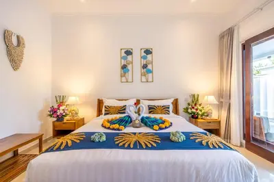 a bedroom with a large bed with a blue and white blanket at Arts Heliconia Villa Two-Bedroom Private Pool Kuta in Kerobokan
