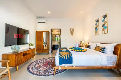 a bedroom with a large bed and a dresser at Arts Heliconia Villa Two-Bedroom Private Pool Kuta in Kerobokan