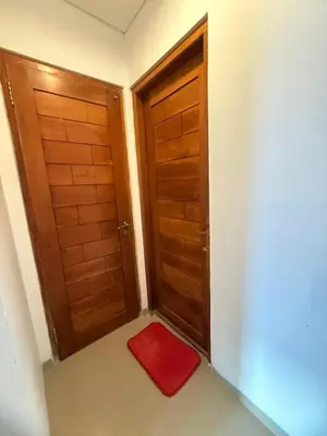 a small room with two doors and a red rug at Home Stay Room in Bali Near Sanur Beach in Sanur