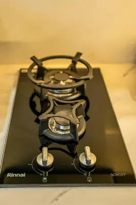 a black stove with a pot on top of it at Divija Villa by Unicorn Villas Bali in Kerobokan