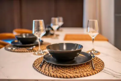 a table with two bowls and wine glasses on it at Divija Villa by Unicorn Villas Bali in Kerobokan