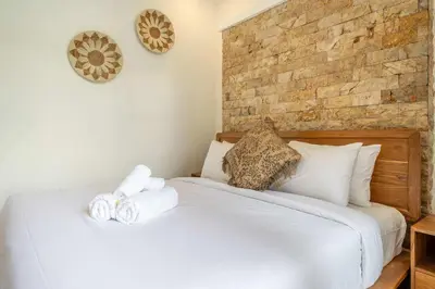 a bedroom with a white bed with towels on it at 3BR Pool Villa in Berawa - Walk to Beach & Cafes in Canggu