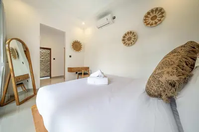 a bedroom with a white bed and a mirror at 3BR Pool Villa in Berawa - Walk to Beach & Cafes in Canggu
