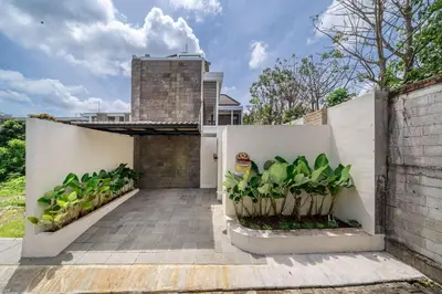 a courtyard with plants on a white fence at 3BR Pool Villa in Berawa - Walk to Beach & Cafes in Canggu