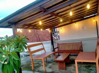 a patio with two benches and a table and awning at RBE Hotel Kuta 3- 5 Min to Airport&Beach by Micky Studio in Ngurah Rai International Airport
