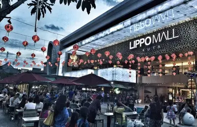 a group of people sitting at tables outside of a building at RBE Hotel Kuta 4- 5 Min to Airport&Beach by Micky Studio in Ngurah Rai International Airport