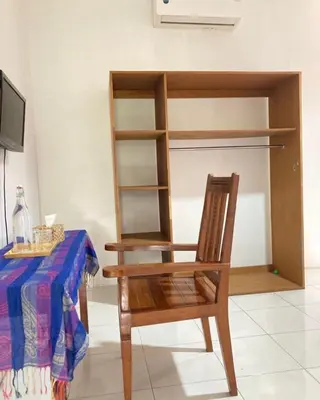 a wooden chair sitting in front of a table at RBE Hotel Kuta 4- 5 Min to Airport&Beach by Micky Studio in Ngurah Rai International Airport