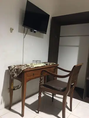 a desk with a chair and a television on a wall at RBE Hotel Kuta 4- 5 Min to Airport&Beach by Micky Studio in Ngurah Rai International Airport