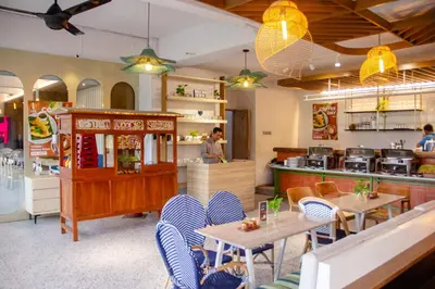 a restaurant with tables and chairs and a counter at Koa D Surfer Hotel in Canggu