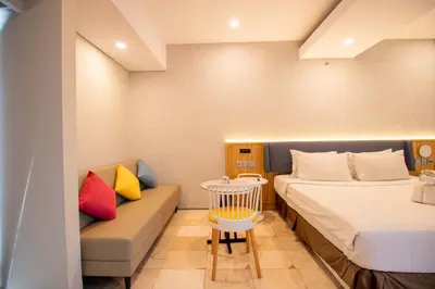 a hotel room with two beds and a couch at Koa D Surfer Hotel in Canggu