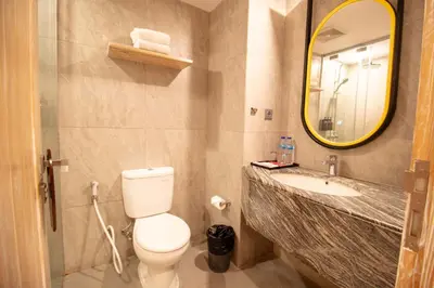 a bathroom with a toilet and a sink and a mirror at Koa D Surfer Hotel in Canggu