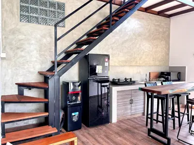 a staircase in a kitchen with a refrigerator and a table at Villa Loba Sanur in Sanur