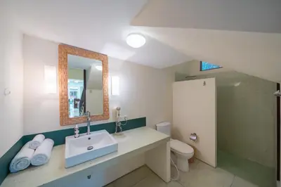 a bathroom with a sink and a toilet and a mirror at The Cemara Umalas in Kerobokan