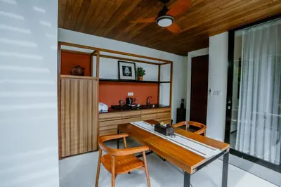 a dining room with a wooden table and chairs at Abia Villa Legian in Legian