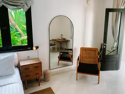 a bedroom with a mirror and a chair and a table at Lovely 2 Bedroom Pool Villa Close to The Beach in Seminyak
