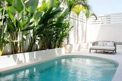 a swimming pool in a room with plants at Villa Amare in Kerobokan