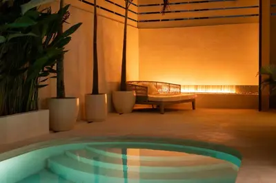 a pool in a room with a couch and a bench at Villa Amare in Kerobokan