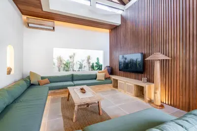 a living room with a green couch and a table at Kin House Bali in Seminyak