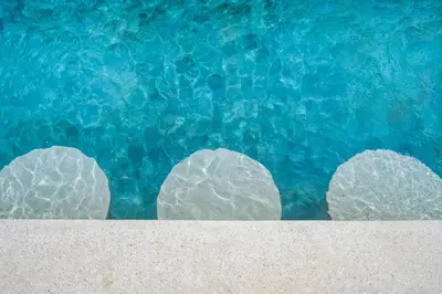 three rocks on top of the blue water at Kin House Bali in Seminyak