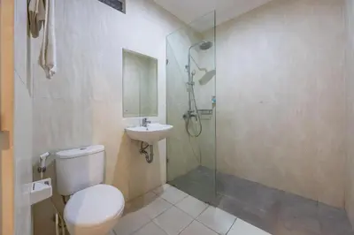 a bathroom with a shower and a toilet and a sink at Cove Vin Stay Petanu in Pesanggaran