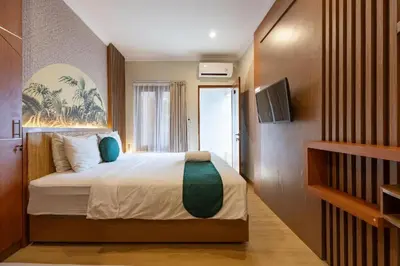 a bedroom with a bed and a television in a room at Cove Vin Stay Petanu in Pesanggaran