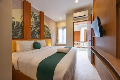 a bedroom with a large bed and a flat screen tv at Cove Vin Stay Petanu in Pesanggaran