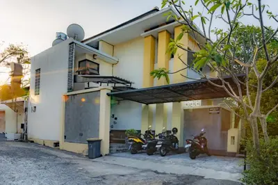 two motorcycles parked in front of a building at TheNadram Guest House in Kerobokan