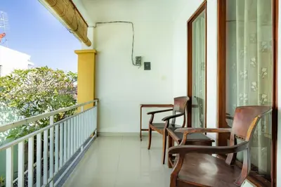 two chairs on the balcony of a house at TheNadram Guest House in Kerobokan