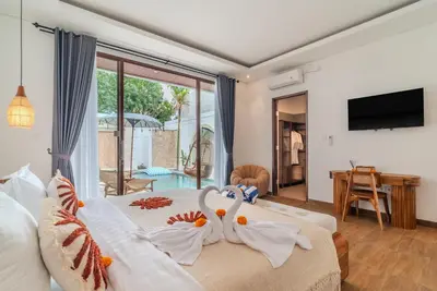 a bedroom with a bed with swans on it at Villa O'Anne 3 in Seminyak