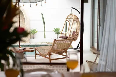 a patio with a swing chair and a pool at Villa O'Anne 3 in Seminyak