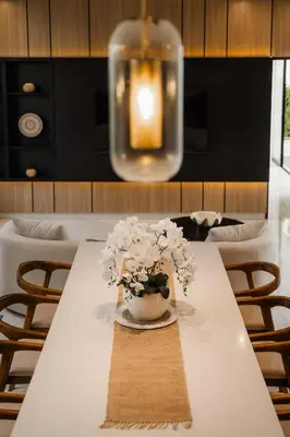 a table with a vase with white flowers on it at Villa Toku by BaliSuperHost in Seminyak