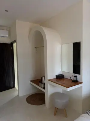 a room with a table and a chair and a mirror at Villa Bambu in Sanur