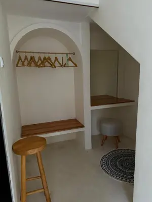 a room with a table and a stool and a shelf at Villa Bambu in Sanur