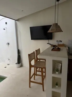 a kitchen with a table and two chairs and a tv at Villa Bambu in Sanur