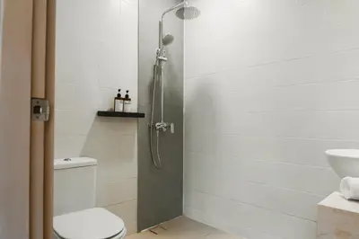 a bathroom with a shower with a toilet and a sink at Iryla Villa Bali in Seminyak