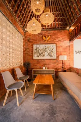 a room with a couch and two chairs and a table at Kuta Sekeca CoWorking Apartment Close to Kuta Beach in Jimbaran