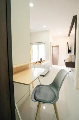 a desk and a chair in a room with a bed at Kuta Sekeca CoWorking Apartment Close to Kuta Beach in Jimbaran