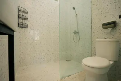 a bathroom with a toilet and a shower at Kuta Sekeca CoWorking Apartment Close to Kuta Beach in Jimbaran