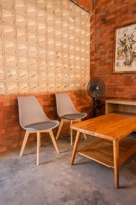 two chairs and a table in a room with a brick wall at Kuta Sekeca CoWorking Apartment Close to Kuta Beach in Jimbaran